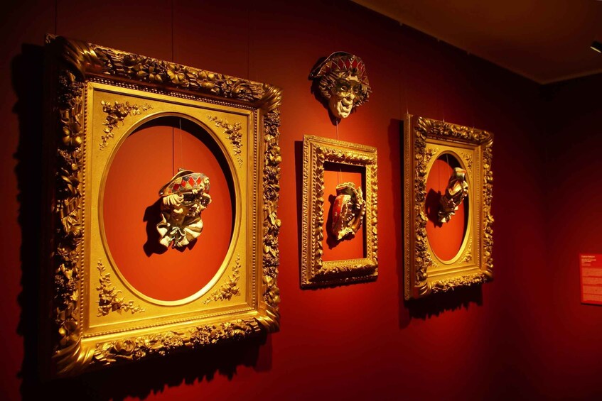 Ornate golden frames with a central circular design, displayed on a red wall. 1