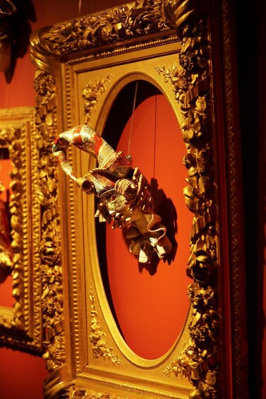 A golden ornate mirror with a red background. 3