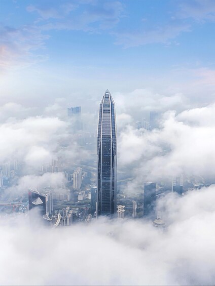A tall skyscraper surrounded by clouds. 5