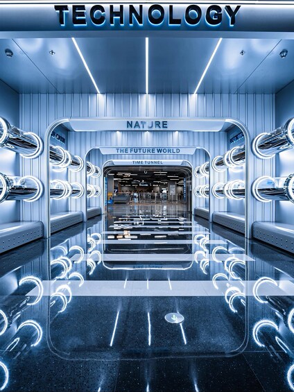 A futuristic interior with a sign reading 'TECHNOLOGY' and 'NATURE THE FUTURE WORLD TIME TUNNEL'. 1