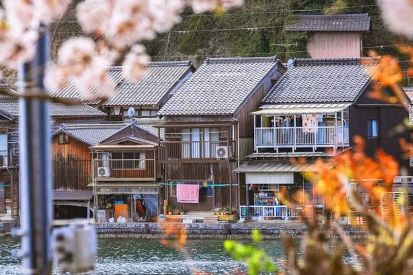 Traditional wooden houses by a waterfront, with a clear sky above. 3