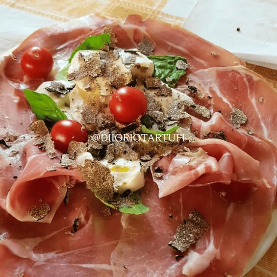 A plate of prosciutto with tomatoes, basil, and a dollop of cream. 4
