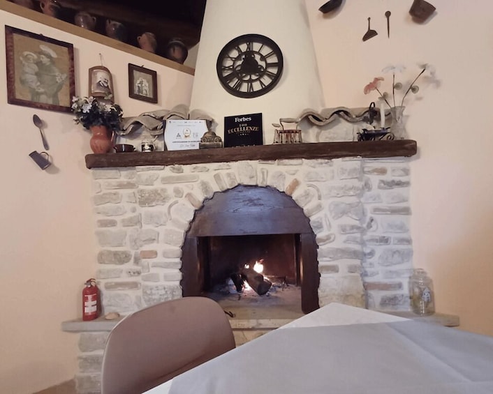 A stone fireplace with a clock above it, surrounded by various decorative items. 3