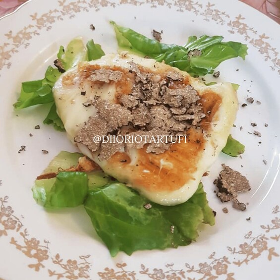 A plate with a heart-shaped food item, possibly a pastry, topped with crumbled meat, surrounded by green leaves, possibly lettuce. 2