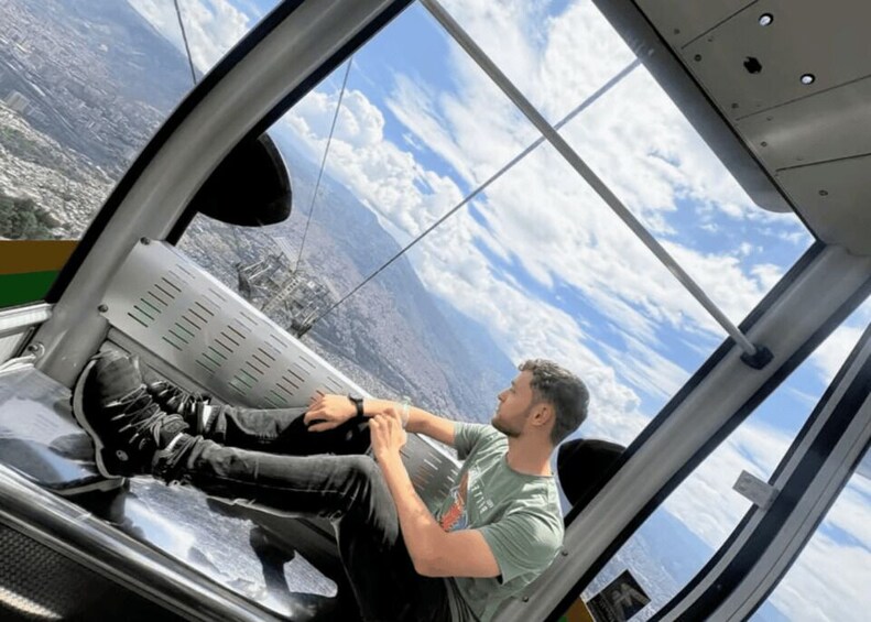 A person seated in a vehicle with a view of a cityscape through a window. 2