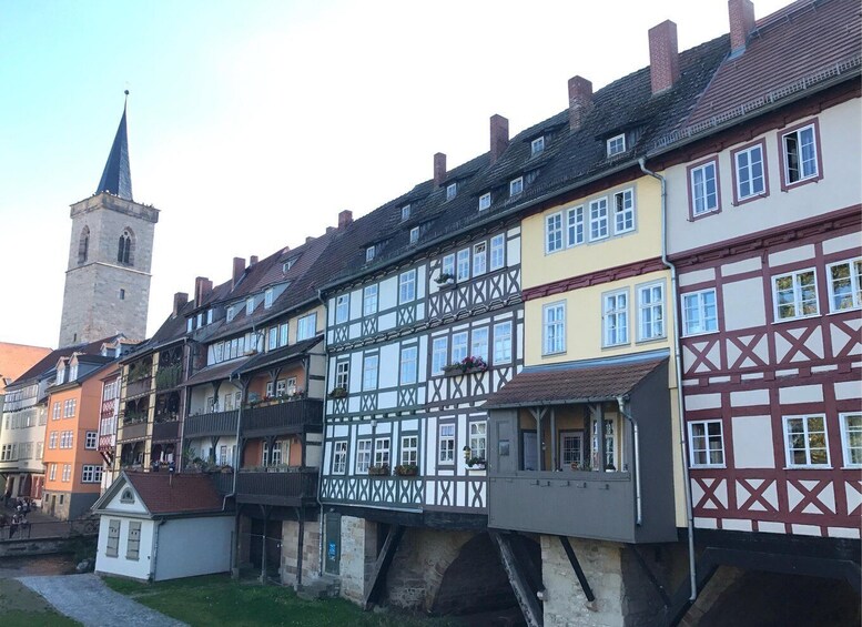 A row of traditional half-timbered houses with a church tower in the background. 3