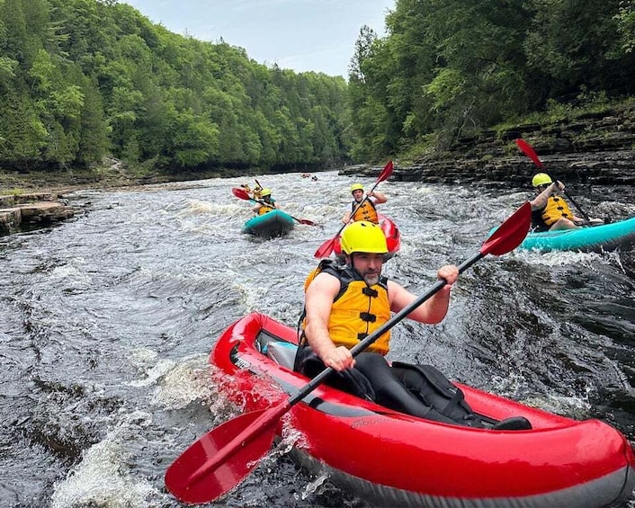A person kayaking on a river surrounded by forest. 4