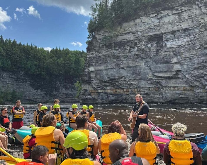 A group of people in yellow life jackets on a boat near a rocky cliff. 5