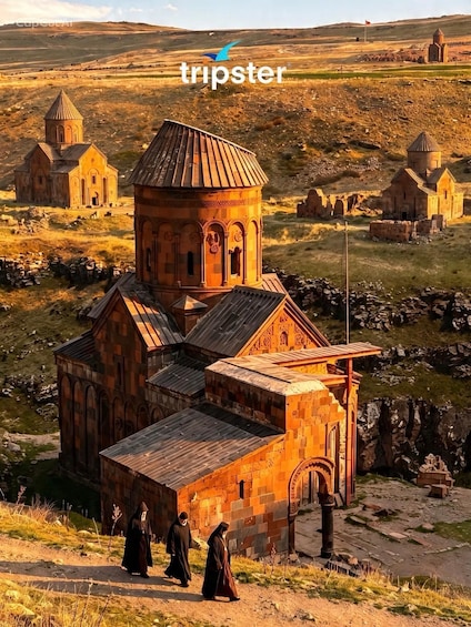A rural landscape with a prominent church and several smaller buildings, likely of historical significance. 1
