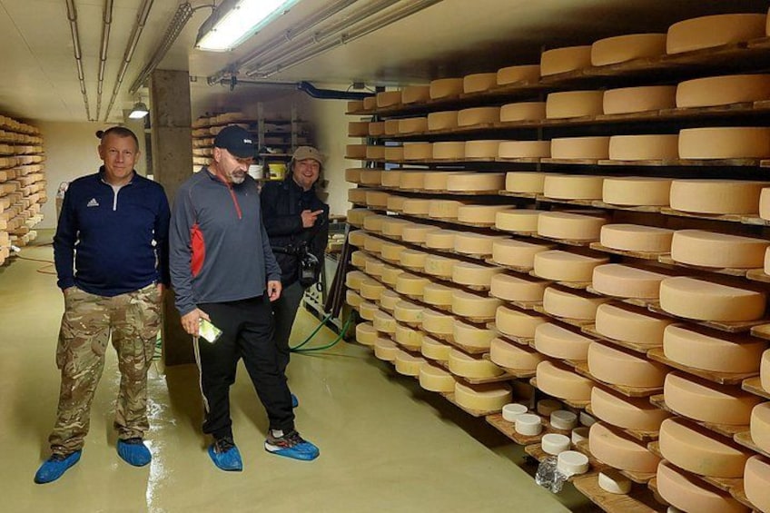 A cheese aging room with rows of cheese wheels. 5