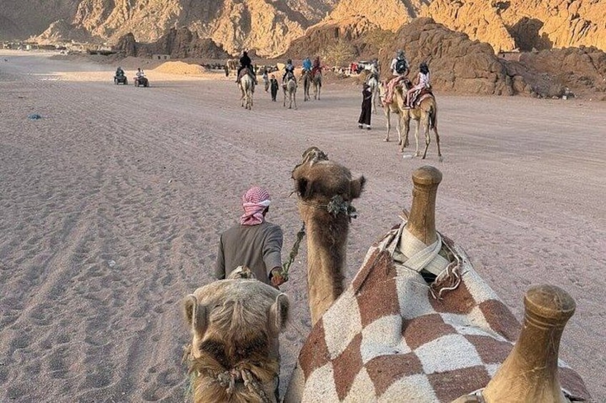 A desert landscape with camels and riders. 2