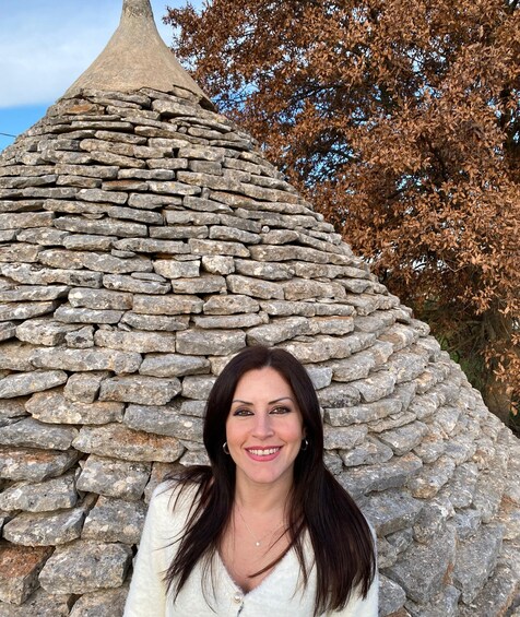 A stone structure with a conical roof, surrounded by trees with autumn leaves. 3
