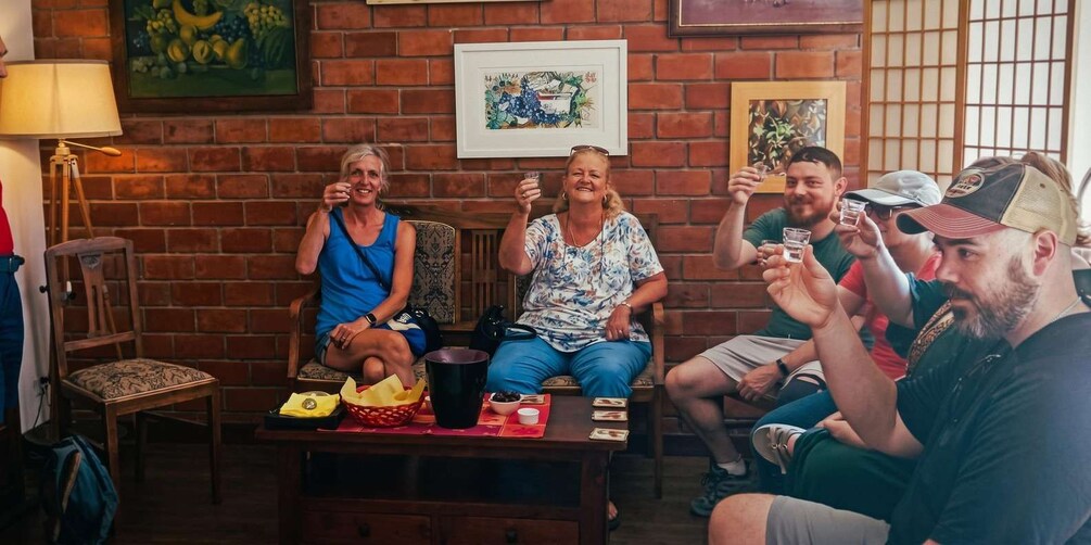 A group of people sitting on chairs in a room with brick walls and framed artwork. 5