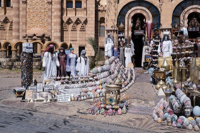 A market with colorful pottery and a historic building in the background. 2