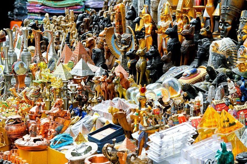 Un étal de marché proposant divers objets d’art égyptiens, notamment des statues, des bijoux et des objets de décoration. 4