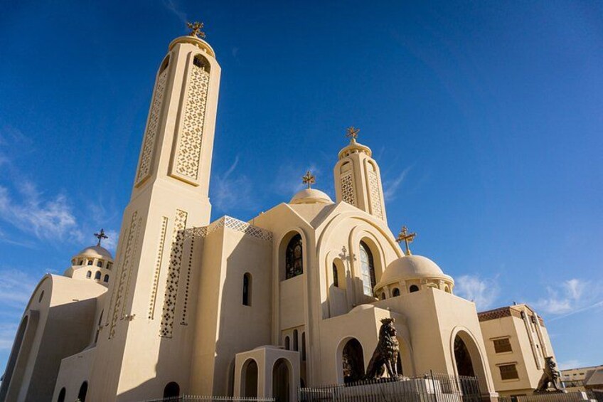 Una iglesia color beige con dos torres altas y una estatua al frente. 3