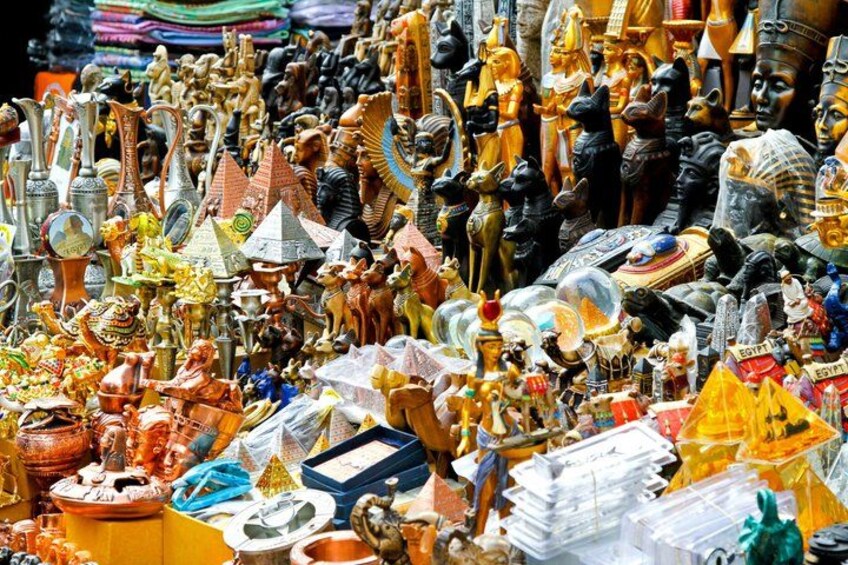 Un puesto de mercado con diversos artefactos egipcios, incluyendo estatuillas, joyería y objetos decorativos. 5