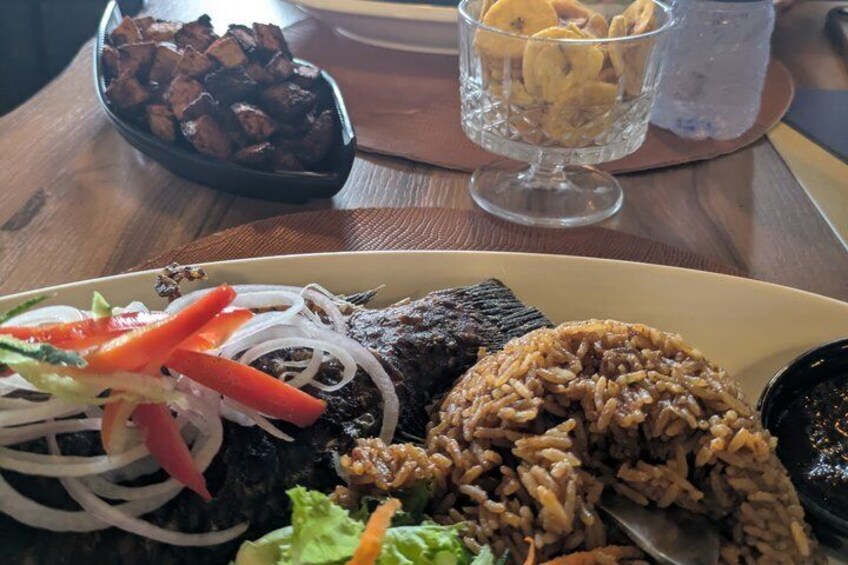 A plate of food with rice, grilled meat, and vegetables. 4
