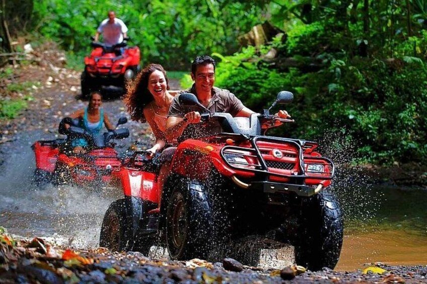 Des personnes conduisent des quads sur un chemin boueux, et l’eau éclabousse tout autour. 2