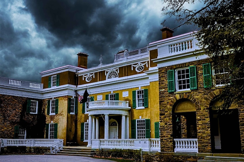 A historic building with green shutters, a white balcony, and a stormy sky. 4