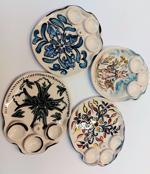Four ceramic plates with various floral and animal designs. 4