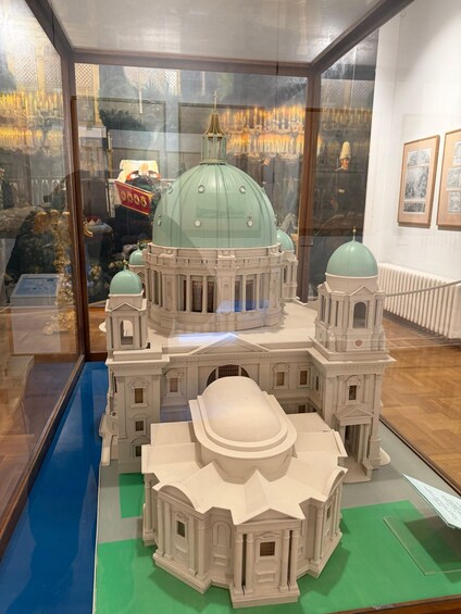 A model of a grand building with multiple domes and a central dome, displayed in a museum setting. 4