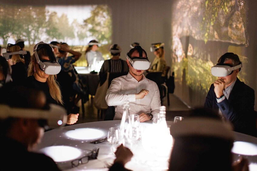People wearing virtual reality headsets at a dining event. 5