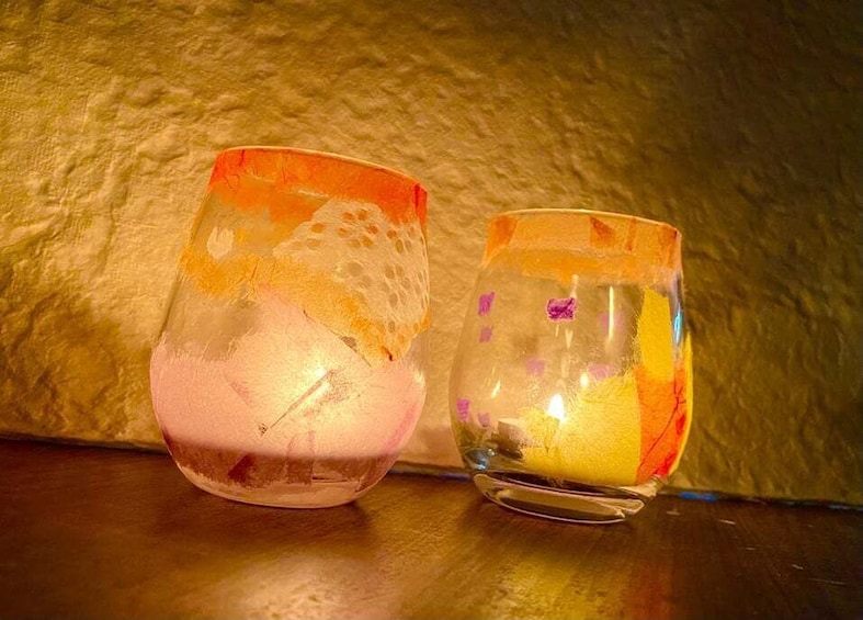 Two glass containers with colorful patterns on a textured surface. 5
