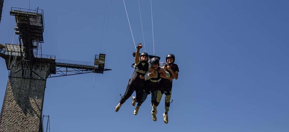 A group of people bungee jumping from a tall structure. 1