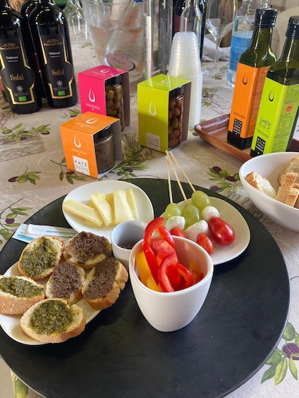A table with food items, including bread with pesto, cheese, grapes, and olives. 3