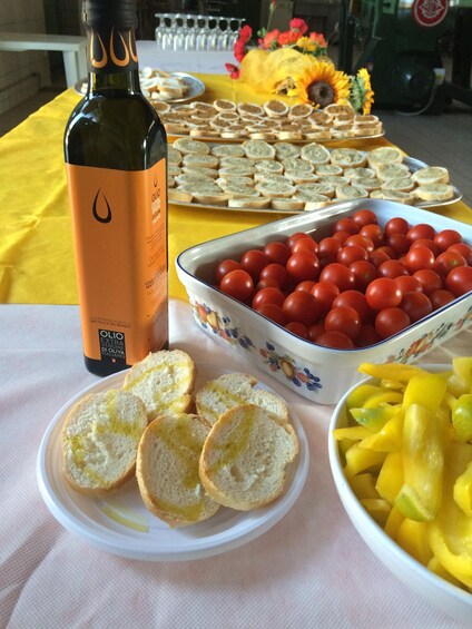 A table with bread, tomatoes, and a bottle of olive oil. 2