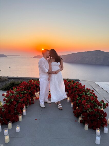 A couple embracing at sunset with a sea and hills in the background. 2