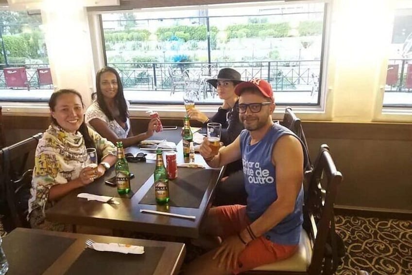 A group of people sitting at a table in a restaurant with drinks and a menu. 2