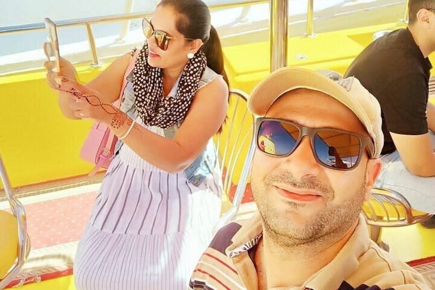 A person in a striped dress and a man in a cap on a yellow bus. 4