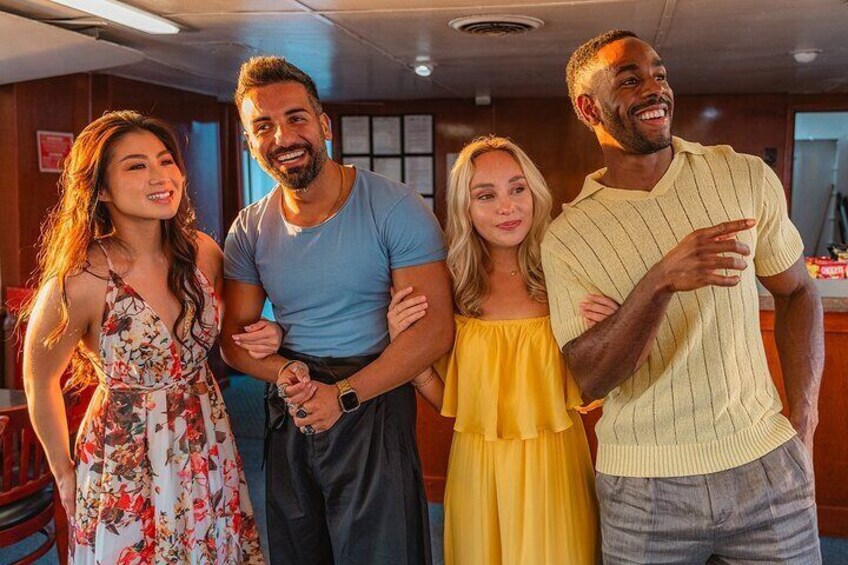 Four people standing indoors, possibly in a bar or restaurant. 3
