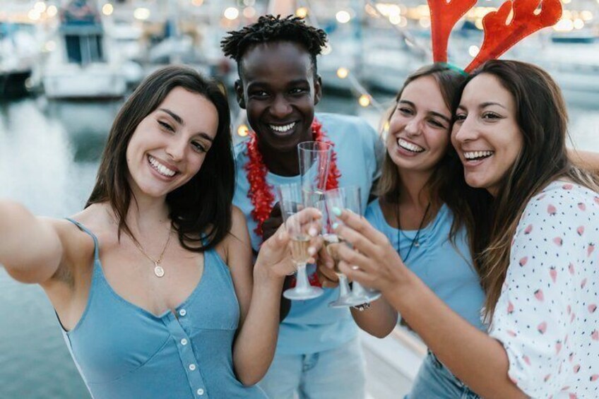 A group of people toasting with drinks at a waterfront. 2