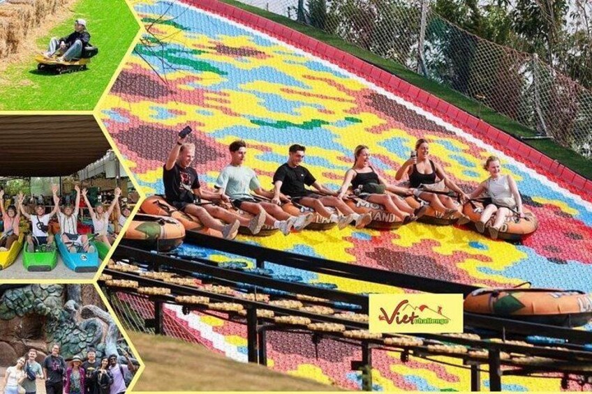 Eine bunte Rutsche, auf deren Unterseite Menschen sitzen und eine Person heruntergleitet. 3