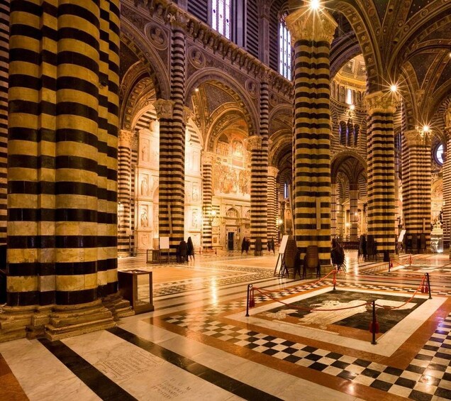 A grand hall with striped columns, a checkered floor, and a large mural. 2