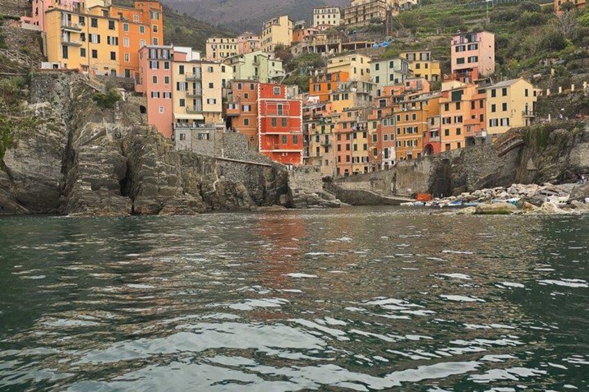 Un pueblo costero con edificios de colores, un litoral rocoso y un puente. 2