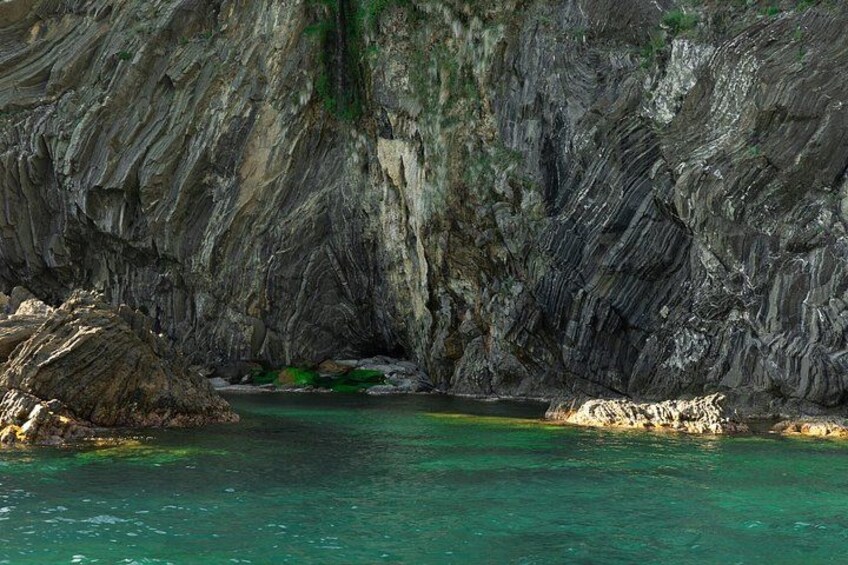 Una cueva costera con aguas turquesas cristalinas y formaciones rocosas escarpadas. 5