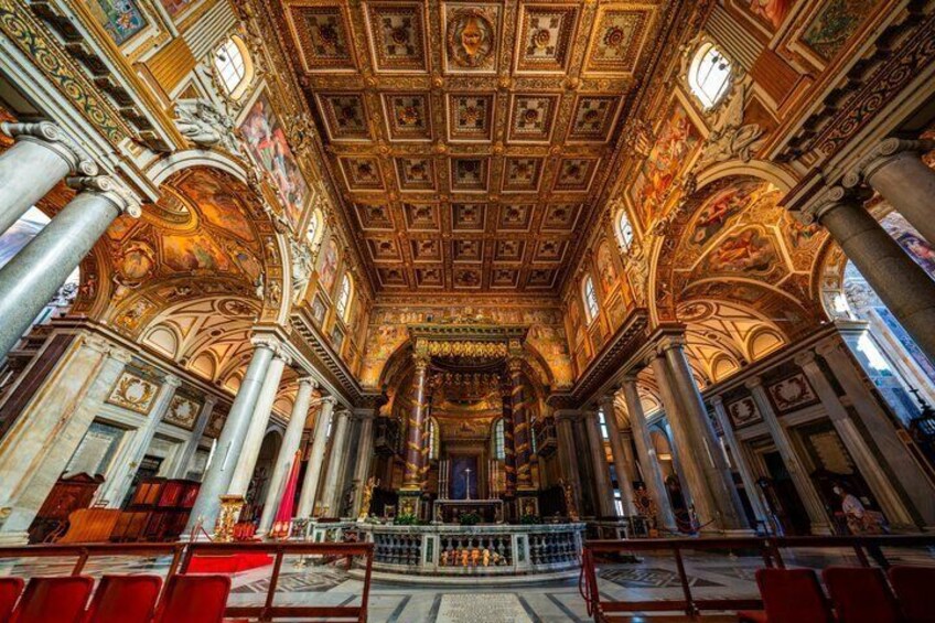 An ornate church interior with high ceilings, detailed frescoes, and classical columns. 4