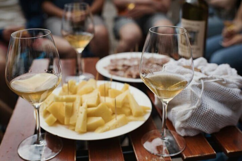A table with plates of food and glasses of white wine. 1