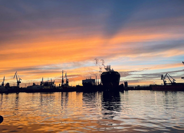 A harbor at sunset with ships and cranes silhouetted against a colorful sky. 5