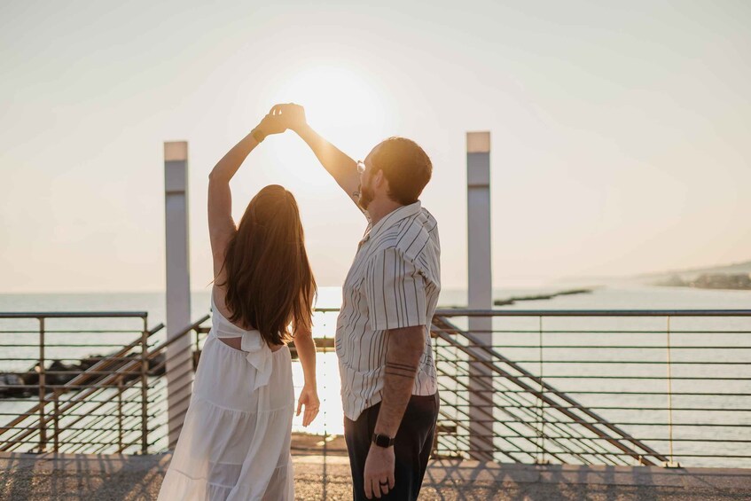 A couple dancing on a bridge with the sun setting in the background. 1