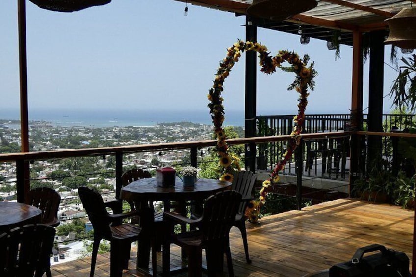 An outdoor patio with a view of the ocean, a heart-shaped floral decoration, and wooden furniture. 5