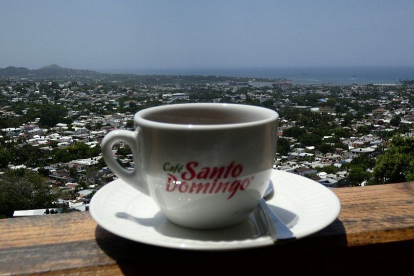 Een koffiekop met de tekst 'Cafe Santo Domingo' erop, geplaatst op een schotel. 4