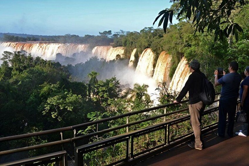 Una cascada con personas observándola desde una plataforma. 1