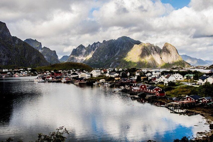 Une ville côtière avec des maisons, un lac paisible et des montagnes en arrière-plan. 2