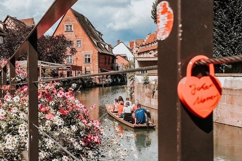 A canal with boats, a heart-shaped lock, and traditional buildings. 1