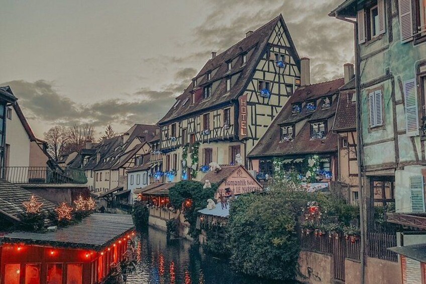 A European town with traditional half-timbered houses, a canal, and festive lights. 3